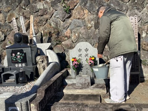 助役の猿渡さんが花に水を足している　　傳肇寺